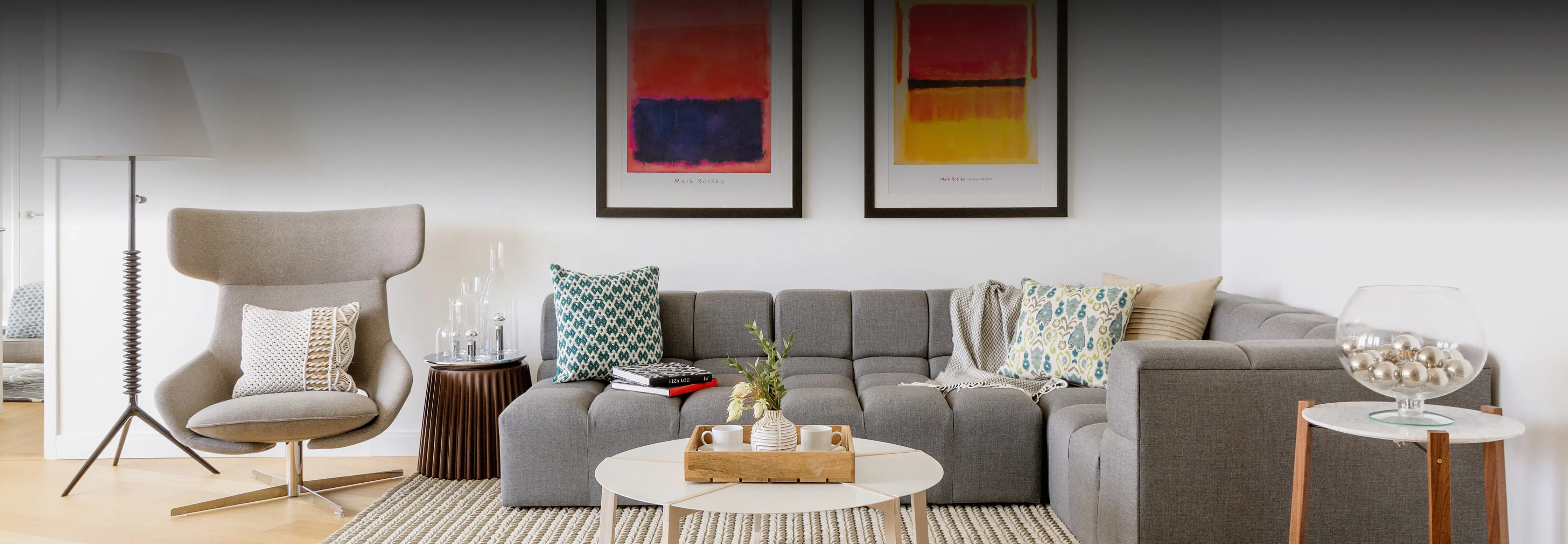 Stylish living room with a gray couch, modern art pieces, and chic decor.